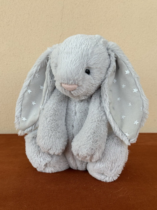 Peluche coniglietto Jellycat Medium Bashful Shimmer grigio chiaro con stelle argento coniglio-