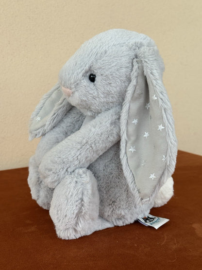 Peluche coniglietto Jellycat Medium Bashful Shimmer grigio chiaro con stelle argento coniglio-